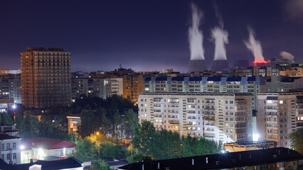 Industrial factory in the modern city. Power plant chimneys. Environment pollution problems