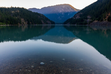 Naklejka na ściany i meble sunrise in still turquoise water of Thunder Arm in Diablo lake in Colonial Creek Campground in North Cascade National park, Washington