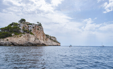 cala Galdana cliff with some sport boats at anchor, cloudy sky, Minorca, Balearic Islands, spain