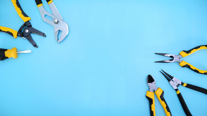different type of yellow and black hand tools flat lay isolated baby blue background with copy space 