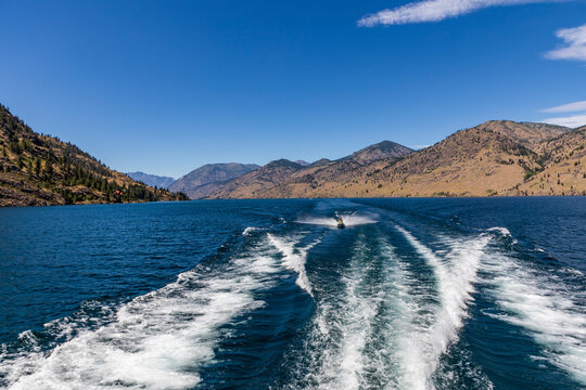 jet skiing in the blue colored Chelan Lake in Washington State during summer.