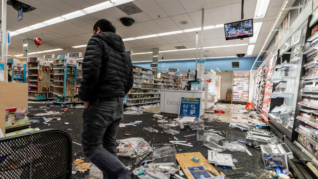 man inspecting store after been looter 