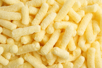 Tasty sweet corn sticks as background, top view