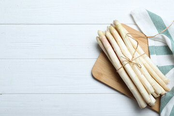 Fresh white asparagus on wooden table, top view. Space for text