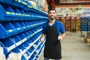 Male worker looking excited while carrying a bunch of new pipes at the hardware store