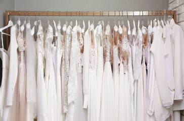 Different wedding dresses on hangers in boutique