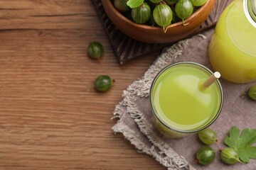 Tasty gooseberry juice on wooden table, above view. Space for text