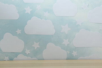 Wooden table near wall with blue sky. Idea for baby room interior