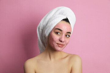 Woman with pomegranate face mask on pink background