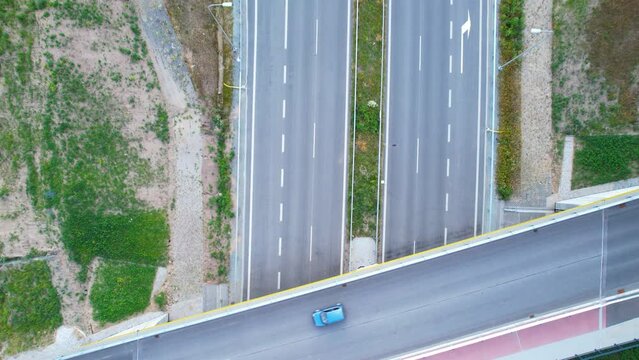 Aerial Top Down Shot Of Blue Car On Bridge Road Crossing In Daylight - Above Asphalt Highway