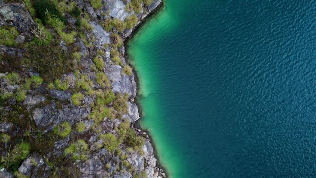 Bird's eye aerial view of the turquoise green lake shore of Lake Quilotoa in Ecuador