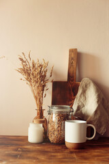 Autumn scene layout. a cup of coffee, wooden cutting boards and dried flowers in the sunlight....