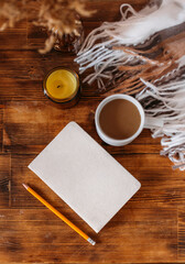 Autumn cozy composition. A cup of coffee, a plaid, a candle, dried flowers on a light background. Autumn, fall concept.