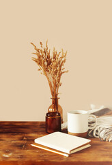 Autumn cozy composition. A cup of coffee, a plaid, a candle, dried flowers on a light background. Autumn, fall concept.