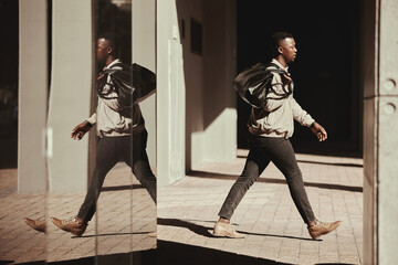 Stylish, travel and a trendy young man walking out of a building or airport in a city. African...