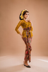 full body portrait of balinese woman wearing brown kebaya over isolated background