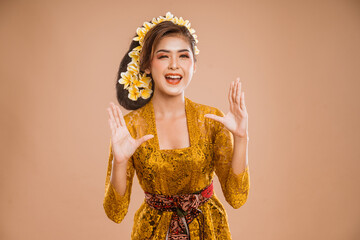 beautiful balinese woman with shouting gesture over isolated background