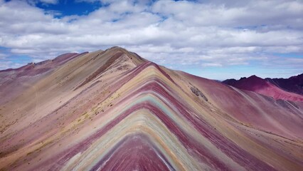 Drone shot of a rocky ridge with reddish ore on the rainbow mountain in Vinicunca