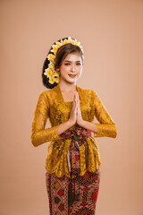 attractive balinese woman in kebaya dress greeting gesture to camera over isolated background