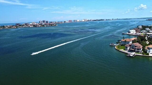 Drone footage shows a speedboat near Belleair Beach racing through the water, creating foamy water splash back.