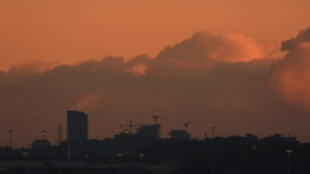 A red hazy sky is full of billowing thick smoke from the large industrial fire