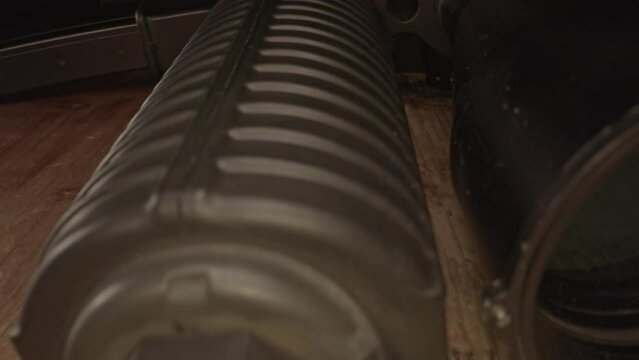 Amazing dolly in of a scoped AR-15 assault rifle barrel and towards hand guard