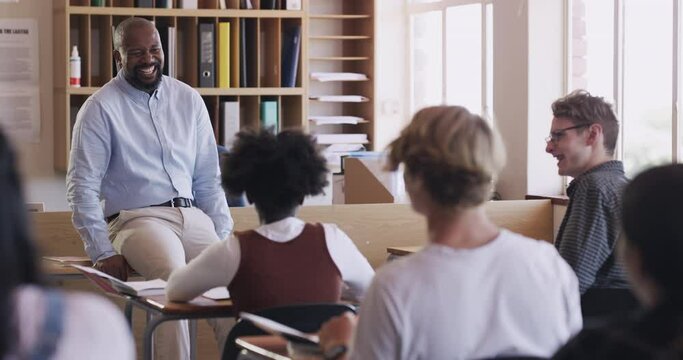 Funny school teacher and students talking, teaching and learning education with teenager youth in high school classroom. Man laughing in study discussion with cheerful and smile group of young kids