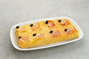 Lekker holland or dutch butter cake (boterkoek), made of butter, flour, eggs and sugar with a sprinkling of sliced ​​almonds and raisins
