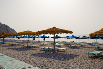 Empty beach with umbrellas and sunbeds. selective focus.The low season.Summer vacation and Covid-19.Beach without people. concept idea for vacation, holiday