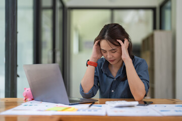 Fototapeta premium Headache, tired and stressed with financial problems desk. Professional female accountant in accounting finance and corporate business doing taxes and debt.