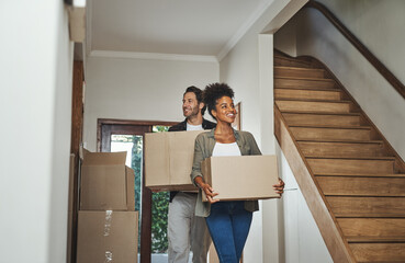 Excited, happy and young couple moving into a new home together while carrying and packing...