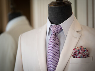 Close up of white tuxedo suit with white shirt, black button and black handkerchief