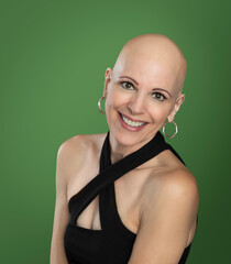 Attractive over 50 woman survivor with alopecia isolated on green background - 525464421