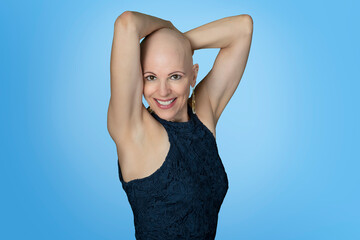 Pretty middle aged bald woman arms on top of head isolated on blue background
- 525464424