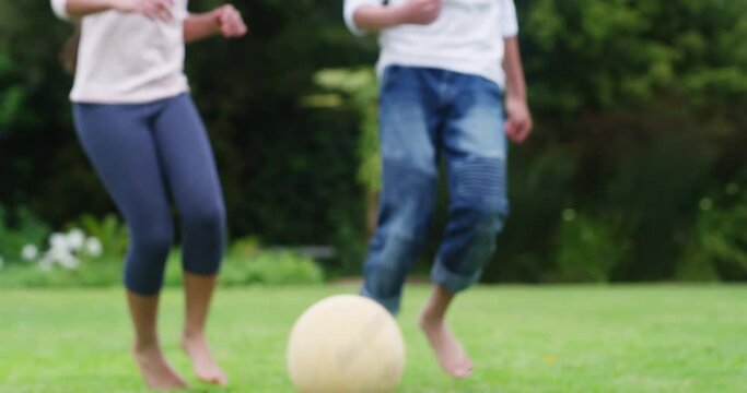 Family, fitness and kids playing football, exercise and fun at home with soccer ball in backyard. Siblings enjoying freedom and energy outdoors, bonding in childhood game and being active in garden