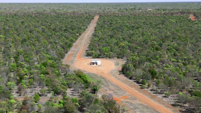 Drone shot of a dirt road on a farm in outback Australia with a huge diesel water bore. Farming equipment on Agricultural farmland