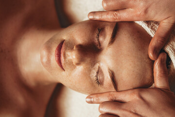 Young attractive woman enjoying massage in spa salon. Beauty treatment. Natural skin care cosmetic....