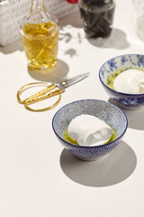 Aesthetic composition with  mozzarella cheese in olive oil. Fresh mozzarella cheese in ceramic bowl. Italian cuisine. Dairy cheese: mozzarella buffalo. Organic food in restaurant menu.