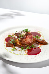 Baked camembert in parma ham on brioche with berry jam. Elegant food - hot appetizer of camembert and ham in summer menu. Cheese appetizer in fine dining. Summer menu.