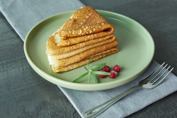Pancakes stacked on a plate with lingonberries. The concept is a morning meal.
