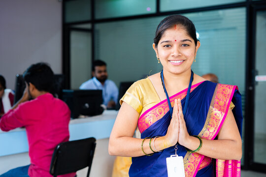 Portrait Shot Of Happy Smiling Bank Employee Greeting By Doing Namaste While Looking Camera In Front Of Customers - Concept Of Gratitude, Welcome Gesture And Custimer Service.