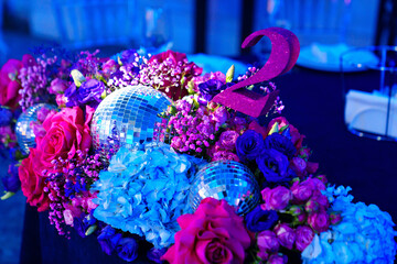 decorated in disco style table in a dark banquet hall. 