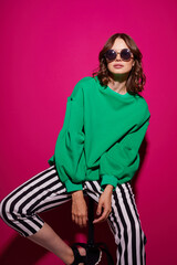 Fashion asian female model in green trendy sweater and pants.