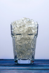Faceted glass filled with ice close-up, still life