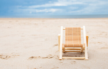 a luxurious deck chair on the shore by the sea to relax and enjoy the view of the summer seascape with thunderclouds