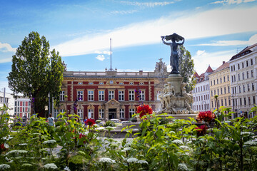 old post office in gorlitz and a fountain on a sunny day