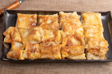 Crispy roti topped with milk in a black plate