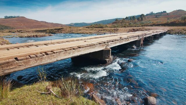 Wooden bridge over the rapid river flowing in Brazilian mountains