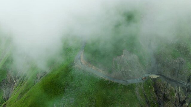 Car Driving Through Abano Mountain Pass Shrouded By Clouds In Georgia. - aerial