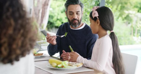 Family, food and love with a father and daughter sharing and eating lunch during a party, birthday or celebration event. Talking, smiling and laughing with a parent and child at a table for a meal